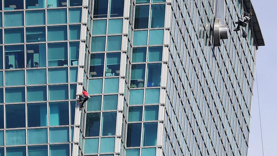 Schaulustige beobachteten Alex Honnold nicht nur vom Boden aus - auch hinter den B&uuml;rofenstern wurde der Extremsportler angefeuert.
