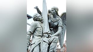 Anscheinend ein Fan von Per&uuml;cken, Schnauzbart und Gehrock, das war die M&auml;nnermode vor 150 Jahren, war der K&uuml;nstler, der B&uuml;rgerdenkmal und Kriegerdenkmal fertigte, die sich sehr &auml;hneln. Hauptunterschied: Einmal h&auml;lt die Bavaria (siehen nebenstehnder Artikel) den Straubinger Helden, einmal ein Engel.