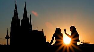 Zwei Frauen vor dem Kölner Dom: Beim ersten Date verzichten junge Leute nach Tinder-Angaben heutzutage lieber auf Alkohol und treffen sich zu kulturellen Aktivitäten oder draußen statt im Restaurant.