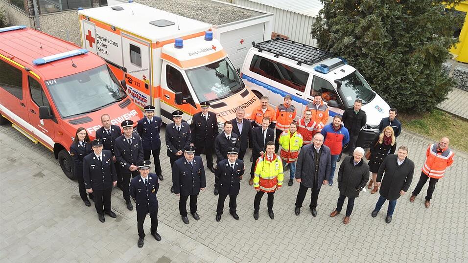 Vertreter von Feuerwehr, Bergwacht und der kommunalen Politik trafen sich zur Projekt-Pr&auml;sentation im Hof der BRK-Gesch&auml;ftsstelle.