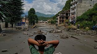 Ein Junge betrachtet die Verw&uuml;stungen durch die Sturzflut in Nepal. (Archivbild)