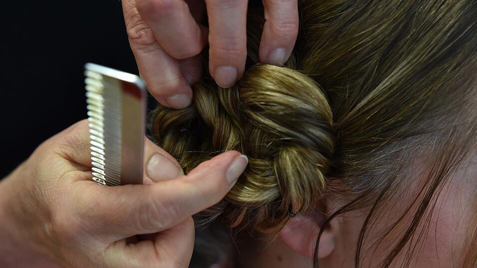 Der Zopf wird nun zu einem Dutt zusammengerollt und mit Haarklammern fixiert. Der Zopf wird nun zu einem Dutt zusammengerollt und mit Haarklammern fixiert.