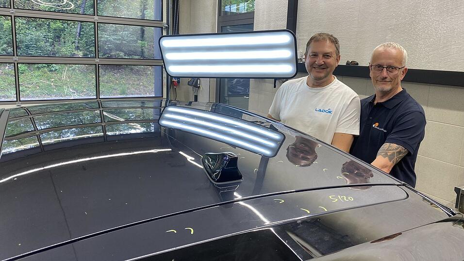 Herbert Kropf, Inhaber der Firma &bdquo;Der Dellendr&uuml;cker&ldquo;, und Zemir Kadiric (links) inspizieren einen betroffenen Wagen.