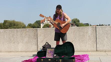 Paul Kreuzer spielt seine eigenen Songs auf der Steinernen Brücke.