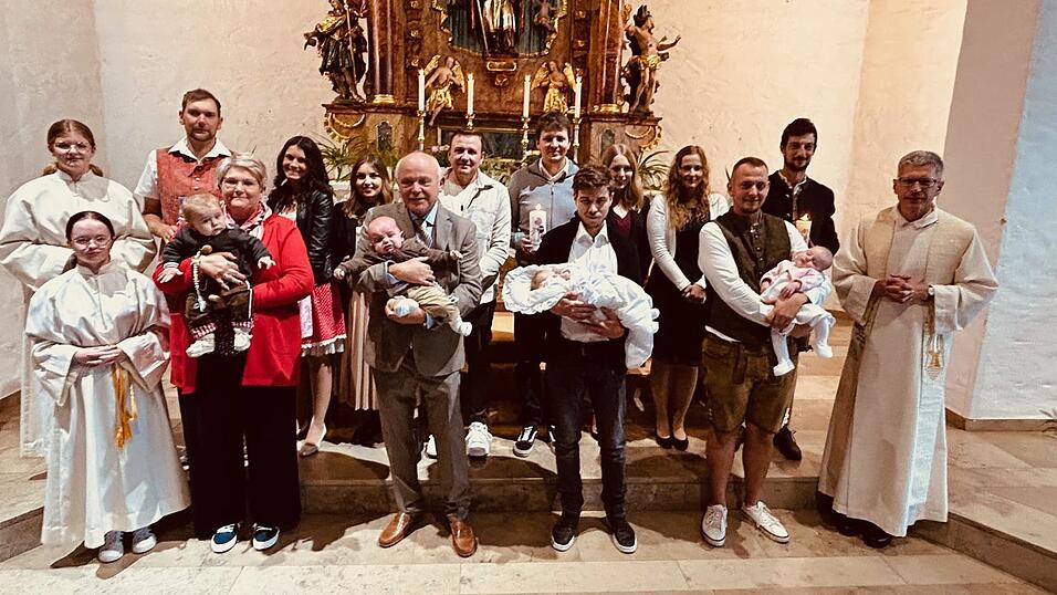 Ben, Julian Josef, Louisa und Hannah (v.l.) auf den Armen ihrer Paten mit ihren Eltern (jeweils dahinter), Pfarrer Johann Wutz und den Ministrantinnen Ben, Julian Josef, Louisa und Hannah (v.l.) auf den Armen ihrer Paten mit ihren Eltern (jeweils dahinter), Pfarrer Johann Wutz und den Ministrantinnen