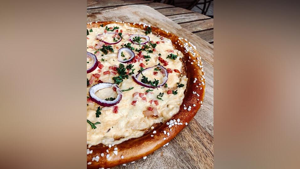 Und so sieht sie aus: die Brizza. Erhältlich in vier verschiedenen Varianten: mit Obazda, Weißwurstscheiben und süßem Senf, Rostbratwürsteln oder saisonal auch mit Spargel. Als Grundlage gibt's Schmand statt Tomatensauce wie auf einer herkömmlichen Pizza.