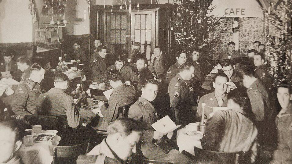 Amerikanische Soldaten feiern Weihnachten 1945 im beschlagnahmten Caf&eacute; Kr&ouml;nner bei Kerzenschein und Christbaumstimmung.