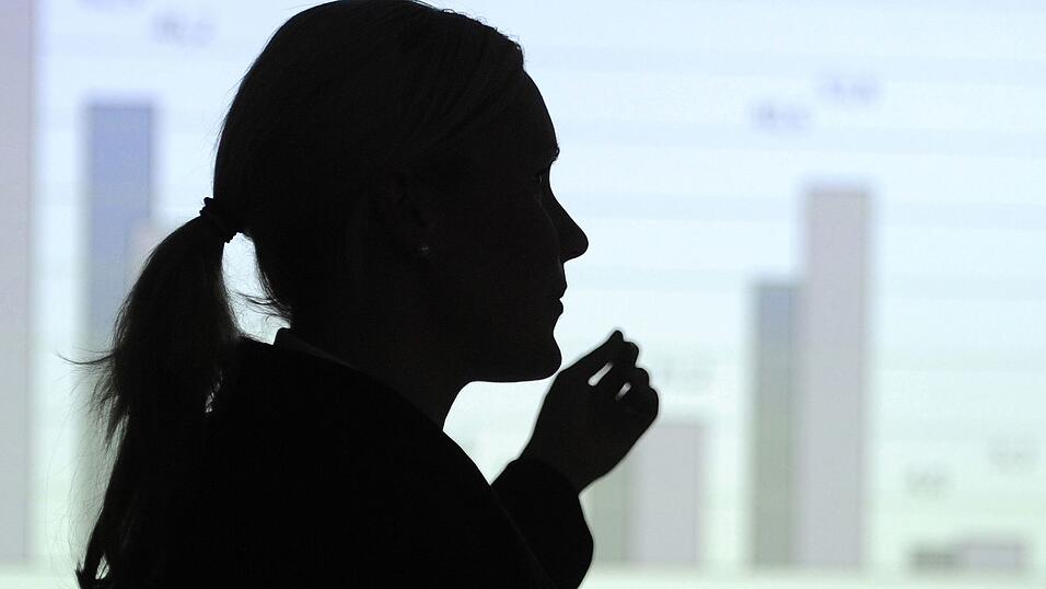 Hier erkl&auml;rt eine Frau eine Statistik an der Wand - vielleicht eine Mutter, die sich bald um ihre Kinder k&uuml;mmern muss? (Illustration)