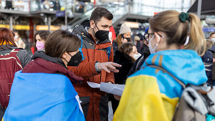 Freiwillige Helfer besprechen sich für die Ankunft von Frauen und Männer aus der Ukraine am Münchner Hauptbahnhof.