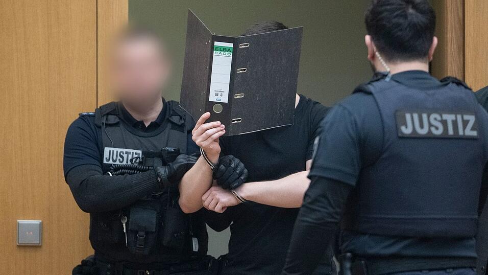 Zwei der M&auml;nner verdeckten beim Betreten des Gerichtssaals ihr Gesicht.