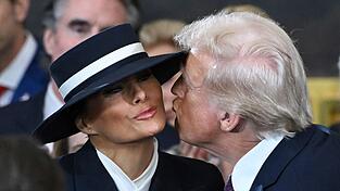 Kurz vor der Amtseinführung Trumps: Der Hut von Melania Trump erschwert ihrem Ehemann Donald einen Kuss auf die Wange.