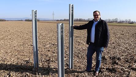 Heute ist die Fl&auml;che, auf der B&uuml;rgermeister Reinhard Knott steht, noch ein Feld. 2027 wird hier der zweitgr&ouml;&szlig;te Solarpark Deutschlands ans Netz gehen. Das Gebiet durchziehen sogenannte Proberahmungen, mit denen getestet wurde, wie der Untergrund beschaffen ist. Eine Hochspannungsleitung ist in unmittelbarer N&auml;he.