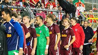 Gefrustete Regensburger um Trainer Michael Wimmer (r.) stellen sich nach der 1:2-Niederlage den mitgereisten Fans.