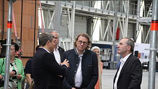 Wirtschaftsminister Hubert Aiwanger (v.r.) mit Stefan Gruber und Thomas Bader beim Rundgang durch die Fertigungshalle.