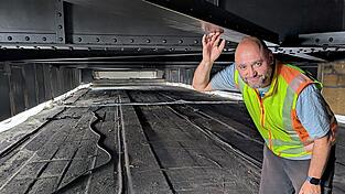 Unter der Brücke: Auf dem Gerüst zeigt Michael Scheerschmidt die fertig sanierten Stahlträger, von denen die hinter der weißen Plane arbeitenden Sanierungsprofis schon rund 75 Prozent für die nächsten Jahrzehnte rostsicher gemacht haben.