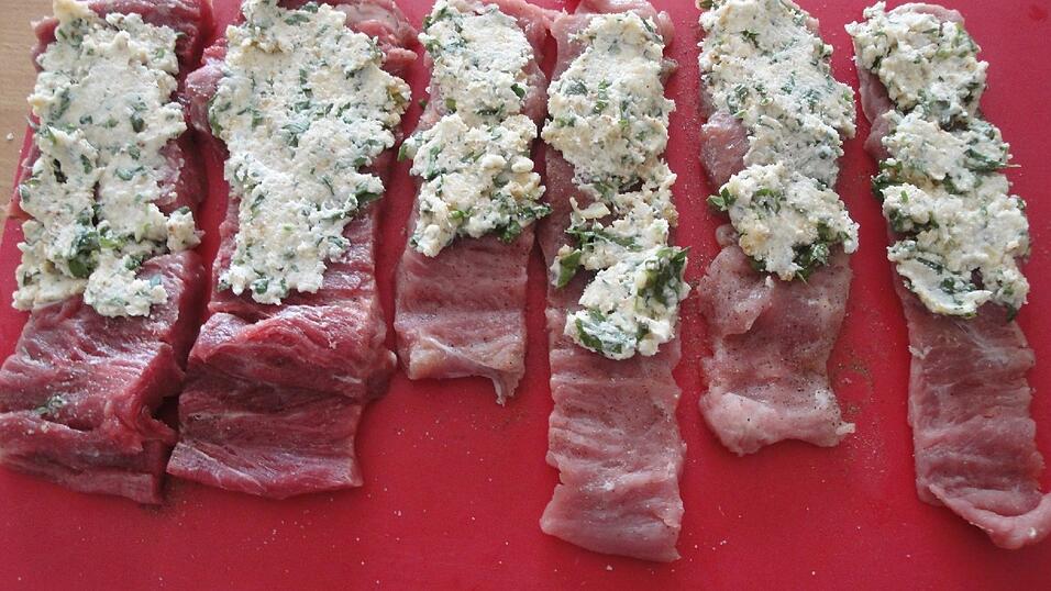 Die cremige Füllung auf die Streifen geben. Dabei unten ein Drittel frei lassen. Nun von oben her aufwickeln.