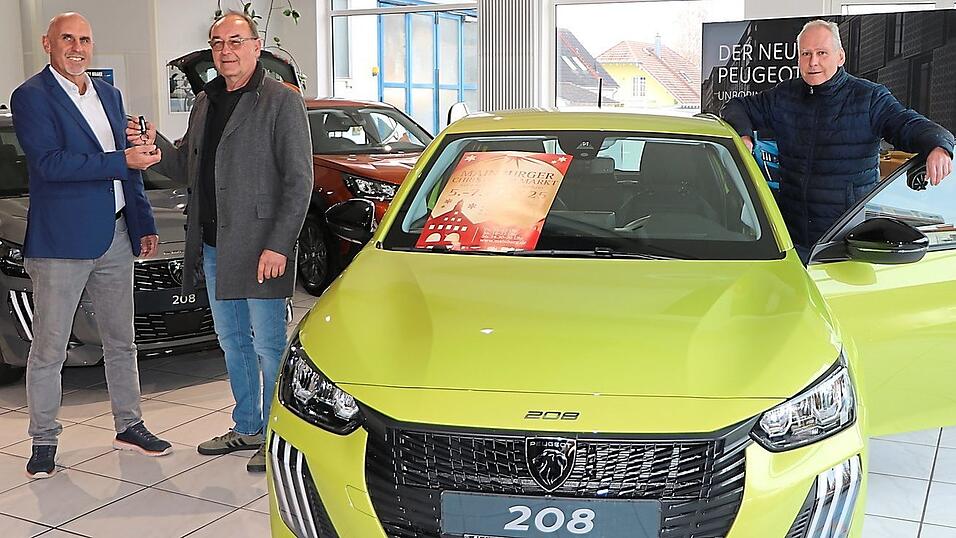 Der 3. Vorsitzende des TSV Sandelzhausen, Armin Mirlach (links), nimmt die Fahrzeugschlüssel von Auto Voit-Seniorchef Rudi Zierer entgegen; rechts Edmund Hohmann.