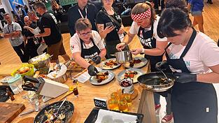 Julia Busch (Mitte) konzentriert sich beim Anrichten der Maultaschen. Ihre Mutter und eine Freundin unterstützen sie dabei.