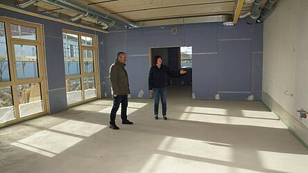 Bürgermeister Johann Aumeier und die Leiterin des Kindergartens, Gabi Prechtl, bei einem Rundgang durch den Anbau. Im großen Gruppenraum sind an der Wand die Anschlüsse für eine neue Küchenzeile bereits montiert.