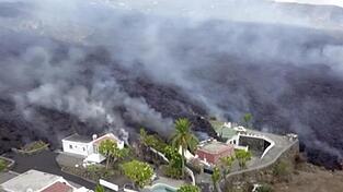 Häuser an einem Hang werden von Lava zerstört. Erstmals seit 50 Jahren ist auf der spanischen Kanareninsel La Palma wieder ein Vulkan ausgebrochen.
