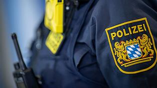 Eine Polizistin trägt ein Abzeichen der bayerischen Polizei.