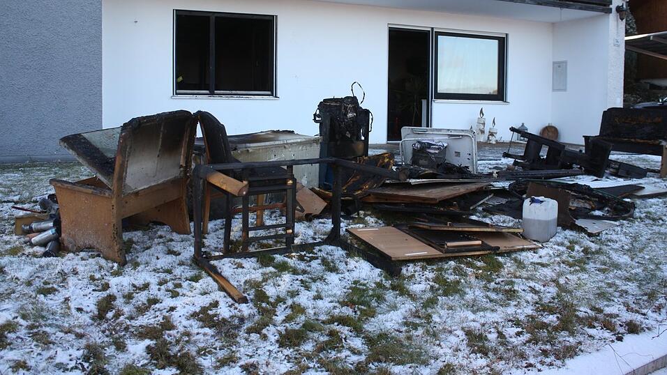 Das Erdgeschoss des Wohnhauses ist stark verraucht. Drau&szlig;en stapeln sich angekokelte M&ouml;bel.