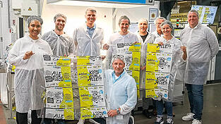 Mitarbeiter von Bischof+Klein, Wepa, Goldeimer und Wildplastic halten die bedruckte Goldeimer-Folie im Werk Konzell in der Hand.