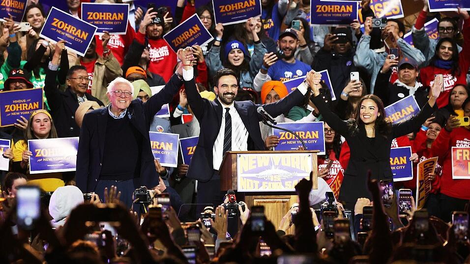 Mamdani trat an der Seite von Sanders (l) und Ocasio-Cortez (r) auf. Mamdani trat an der Seite von Sanders (l) und Ocasio-Cortez (r) auf.
