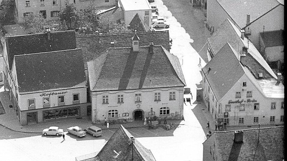 Diese Luftaufnahme von 1958 zeigt rechts neben dem alten Rathaus am Marktplatz das inzwischen abgerissene Gasthaus Bräu. Einige Jugendliche informieren sich gerade am Schaukasten, was am folgenden Wochenende im Kino läuft. Direkt vesetzt rechts angrenzend ist das Kino von oben zu sehen. Auch der kleine Vorführraum unmittelbar an der Nord-Fassade ist zum Teil erkennbar. Über das Gasthaus Bräu gelangte man in den Kinosaal. Diese Luftaufnahme von 1958 zeigt rechts neben dem alten Rathaus am Marktplatz das inzwischen abgerissene Gasthaus Bräu. Einige Jugendliche informieren sich gerade am Schaukasten, was am folgenden Wochenende im Kino läuft. Direkt vesetzt rechts angrenzend ist das Kino von oben zu sehen. Auch der kleine Vorführraum unmittelbar an der Nord-Fassade ist zum Teil erkennbar. Über das Gasthaus Bräu gelangte man in den Kinosaal.