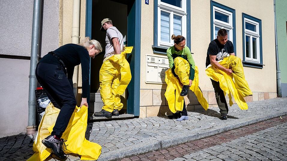 Tatortreiniger arbeiten in Ganzk&ouml;rper-Schutzanz&uuml;gen, mit Atemschutzmasken und Spezialhandschuhen, um sich vor Infektionen durch Krankheitserreger zu sch&uuml;tzen.