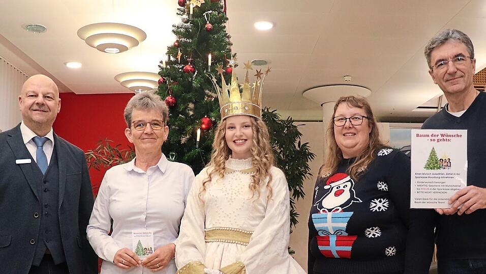Das Moosburger Christkindl Lena Wagner mit (v. l.) Sparkassen-Geschäftsstellenleiter Uwe Pütz sowie Ines Reithmeier, Michaela Fincke und Heiko Bauerschmitt als Vertreter des „Baum der Wünsche“-Teams.