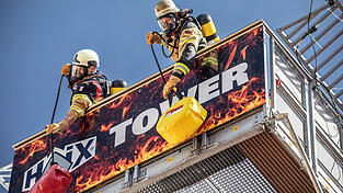 Die Teilnehmer sollen einen 19 Kilo schweren Feuerwehrschlauch den zwölf Meter hohen Turm hochziehen.