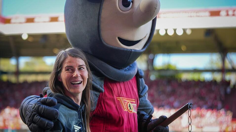 Union-Trainerin Marie-Louise Eta wird von Club-Maskottchen Ritter Keule umarmt.