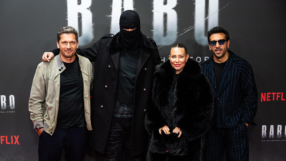 Haftbefehl alias Aykut Anhan (2.v.l.) erschien komplett maskiert zu einer Sonderaufführung der Dokumentation 'Babo - Die Haftbefehl-Story' Ende Oktober in Berlin. Rechts neben ihm stehen seine Frau Nina und Schauspieler Elyas M'Barek. Haftbefehl alias Aykut Anhan (2.v.l.) erschien komplett maskiert zu einer Sonderaufführung der Dokumentation 'Babo - Die Haftbefehl-Story' Ende Oktober in Berlin. Rechts neben ihm stehen seine Frau Nina und Schauspieler Elyas M'Barek.