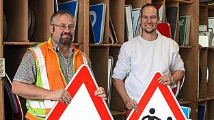 Matthias Einzinger und Stefan Binder stellen die Schilder auf.