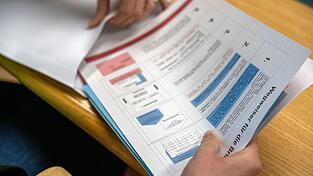 Eine Verwaltungsmitarbeiterin bereitet Unterlagen für die Briefwahl vor.