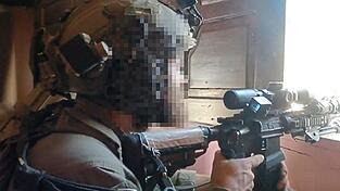 Mit dem Finger am Abzug: Daniel G. aus Bayern blickt durch das Visier eines aufgerüsteten Sturmgewehrs im Gazastreifen.