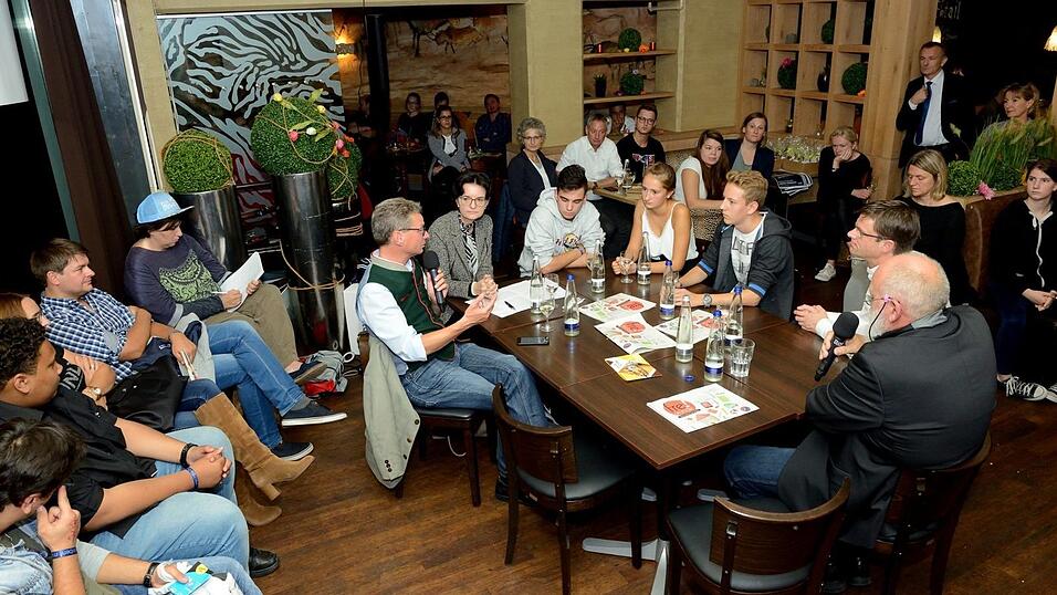 Am Tisch von links: Kultusminister Bernd Sibler mit Moderatorin Sonja Ettengruber und dem Bezirkssch&uuml;lersprecher von Niederbayern, Arda K&ouml;cer (Donau-Gymnasium Kelheim), den Sch&uuml;lern Isabell Hofmann (Ludwigsgymnasium) und Dennis Scheske (Anton-Bruckner-Gymnasium), sowie Markus Engl (stellvertretender Schulleiter des Ludwigsgymnasiums) und Erich Gruber (Rektor der Grund- und Mittelschule St. Josef).