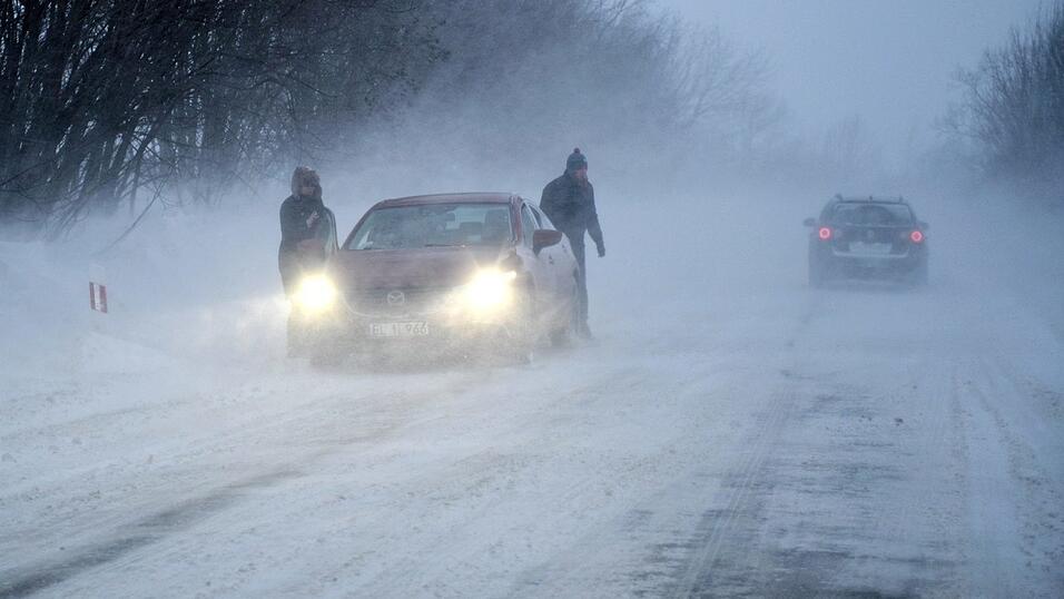 Autos fahren auf einer verschneiten Straße. Viele Städte in Polen sind von starken Schneefällen betroffen. Autos fahren auf einer verschneiten Straße. Viele Städte in Polen sind von starken Schneefällen betroffen.