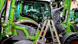 Ein Fendt-Mitarbeiter stellt den Außenspiegel eines Traktors ein. (Archivbild) Ein Fendt-Mitarbeiter stellt den Außenspiegel eines Traktors ein. (Archivbild)