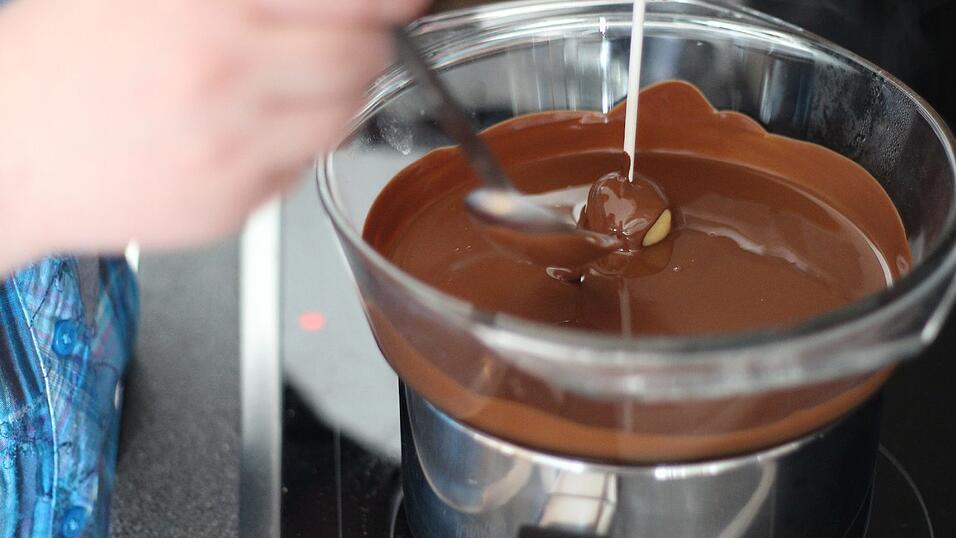 Kuvertüre im Wasserbad schmelzen und die Kugeln damit überziehen. Kuvertüre im Wasserbad schmelzen und die Kugeln damit überziehen.