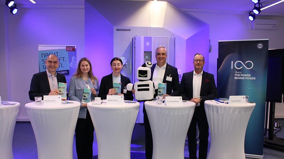 Der Gesch&auml;ftsf&uuml;hrer des Stadtmarketings Michael Quast (von links), die Leitung der Standortkommunikation bei Aumovio Elke Kaczmarek, die Gesch&auml;ftsf&uuml;hrerin von Starkstrom-Ger&auml;tebau Deliana Teneva, der k&uuml;nftige Oberb&uuml;rgermeister Thomas Burger und der Gesch&auml;ftsf&uuml;hrer der Maschinenfabrik Reinhausen Holger Michalka bei der Pressekonferenz im Synergy-Center der Maschinenfabrik Reinhausen.