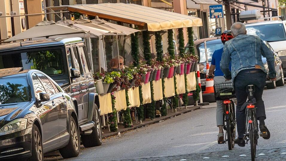 Zwei 'Schanigärten' stehen in München auf dem Parkplatzbereich einer Straße. Zwei 'Schanigärten' stehen in München auf dem Parkplatzbereich einer Straße.