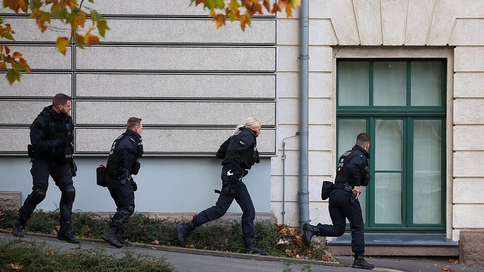 Einsatzkräfte nähern sich bei einer simulierten Amok-Lage vorsichtig an ein Gymnasium an. Einsatzkräfte nähern sich bei einer simulierten Amok-Lage vorsichtig an ein Gymnasium an.