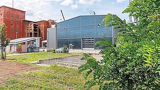 Dort, wo jetzt noch ziegelrote Produktionshallen (links) stehen, soll neben der Klärschlammtrocknung (rechts) eine Verbrennungsanlage gebaut werden.