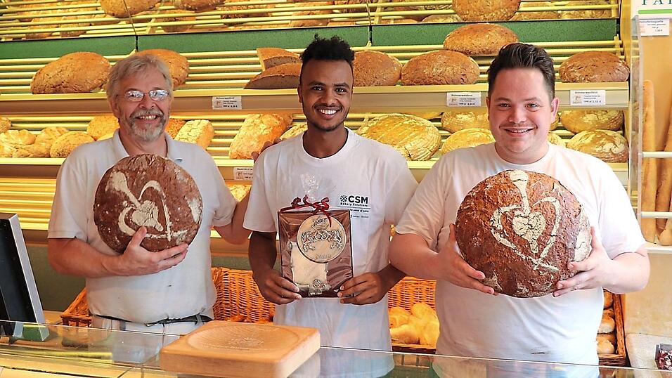 Strahlende Gesichter: Farhan Mahamed ist der beste B&auml;ckergeselle 2019. Seine Chefs Peter (links) und Christian Philipps gratulierten.