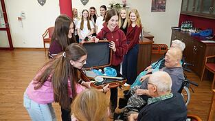 Die Sch&uuml;lerinnen erkl&auml;rten den Senioren den Inhalt des Koffers.