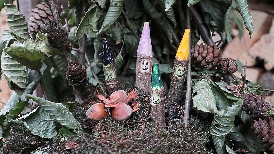 Vier Holzzwerge mit drei Haseln&uuml;ssen.