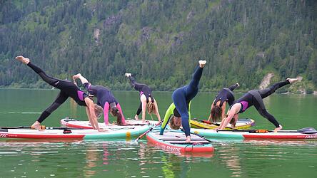 Redakteurin Ulrike (Mitte hinten) bei der Yoga-Übung 'herabschauender Hund' auf dem SUP-Board. Bei schönem Wetter reichen auch normale Badeklamotten. Redakteurin Ulrike (Mitte hinten) bei der Yoga-Übung 'herabschauender Hund' auf dem SUP-Board. Bei schönem Wetter reichen auch normale Badeklamotten.