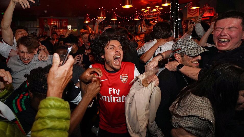 Arsenal-Anhänger feiern in einem Pub in der Nähe des Arsenal-Stadions, nachdem die Fußballmannschaft des FC Arsenal den Titel in der Premier League gewonnen hat. Arsenal-Anhänger feiern in einem Pub in der Nähe des Arsenal-Stadions, nachdem die Fußballmannschaft des FC Arsenal den Titel in der Premier League gewonnen hat.
